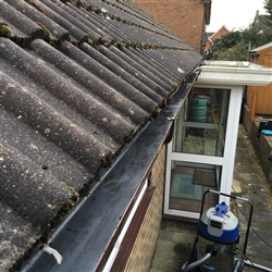 Gutter filled with leaves, moss and rainwater cleared, Ipswich, Suffolk